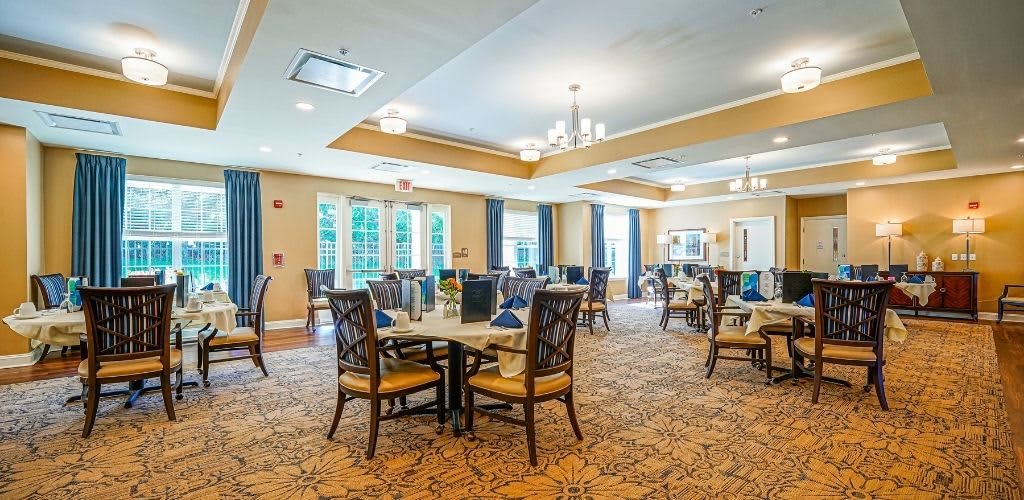 A spacious dining room with elegant furnishings and natural lighting.