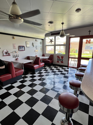 A cozy diner interior with booth seating and a classic checkered floor design.
