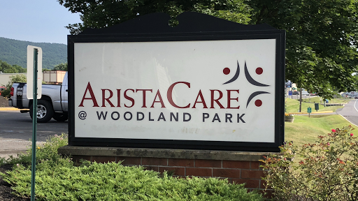 Signage for AristaCare at Woodland Park, indicating a healthcare facility.