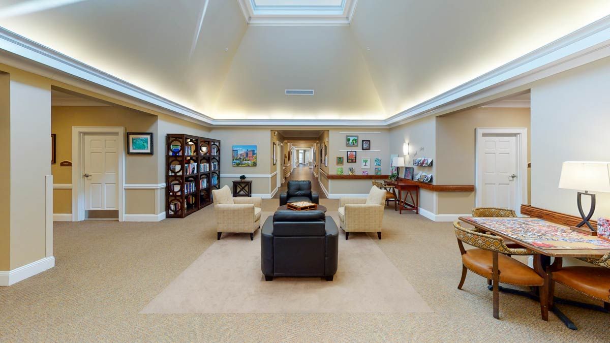 A spacious and well-lit living room with comfortable seating, bookshelves, and decorative elements.