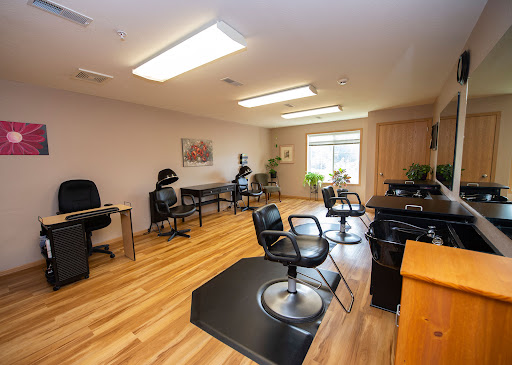 A spacious and well-lit salon with workstations and styling chairs.