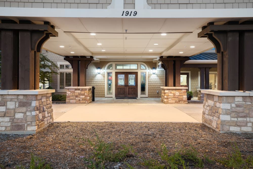 The illuminated entrance of a building with stone columns and decorative lighting.