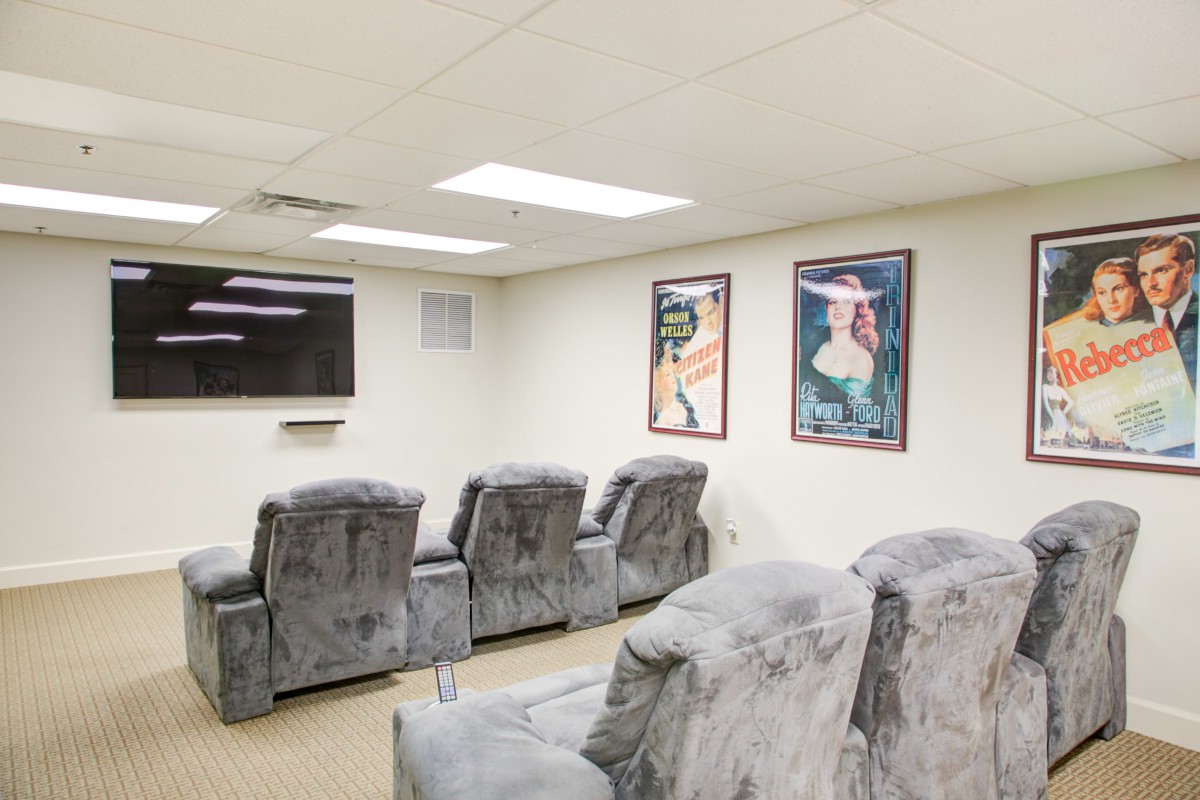 Cozy home theater room with recliner seating and decorative wall art.