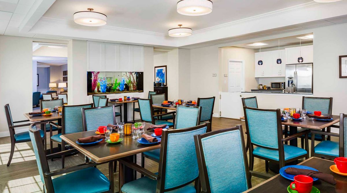 A modern dining area with neatly arranged tables and chairs, featuring colorful table settings and contemporary decor.