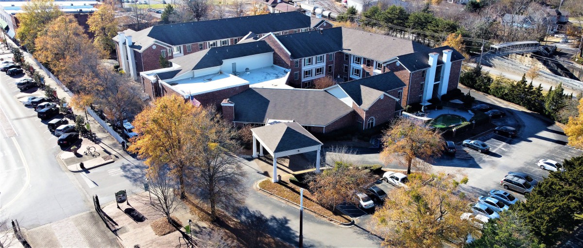Aerial view of a large building complex surrounded by trees during autumn.