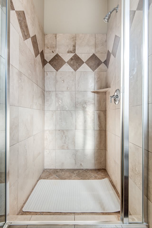 A modern tiled shower interior with geometric patterns.