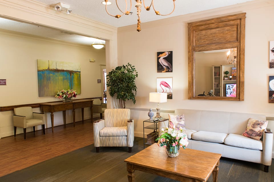 A cozy living room with comfortable seating, a coffee table adorned with flowers, and elegant decor.
