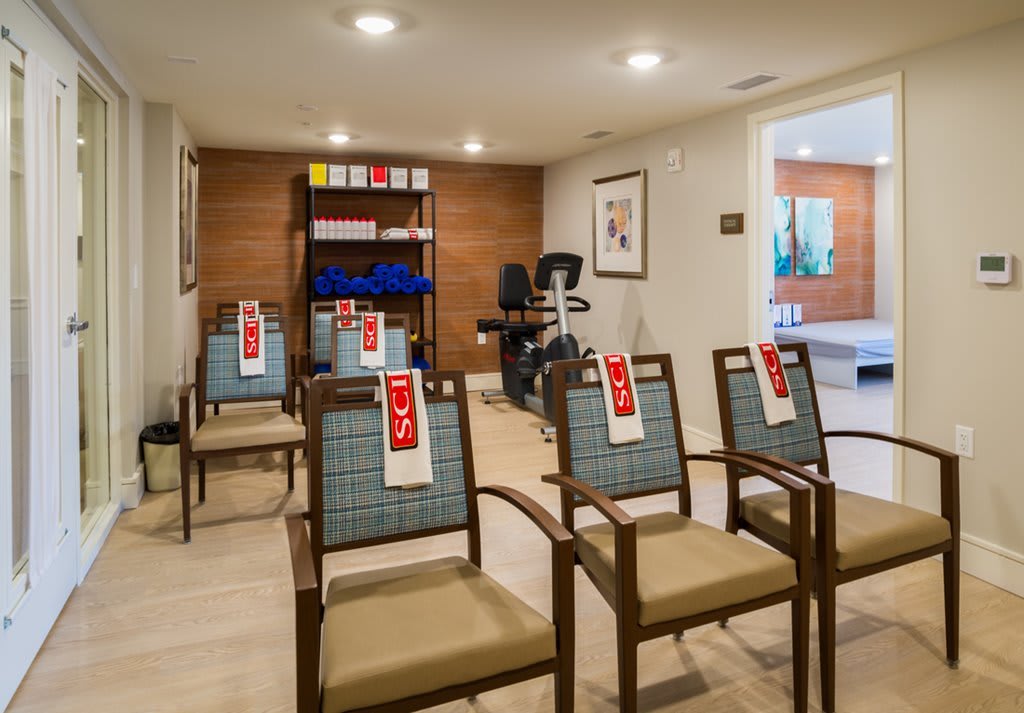 A well-lit waiting area with chairs and exercise equipment.