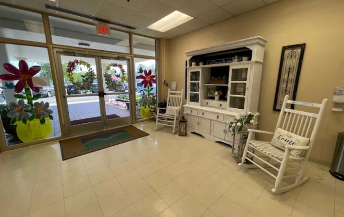 A cozy lobby area with rocking chairs and a decorative cabinet.