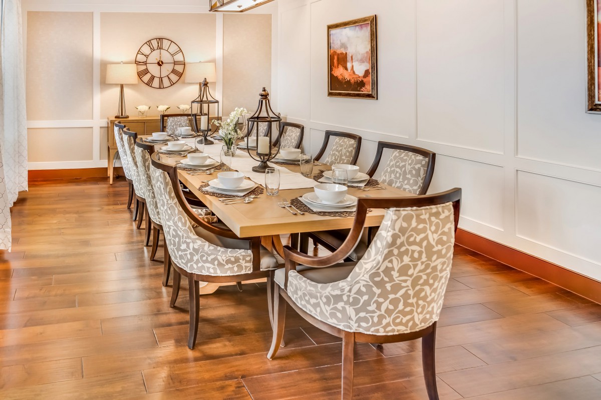 A beautifully arranged dining room with a wooden table and elegant patterned chairs.