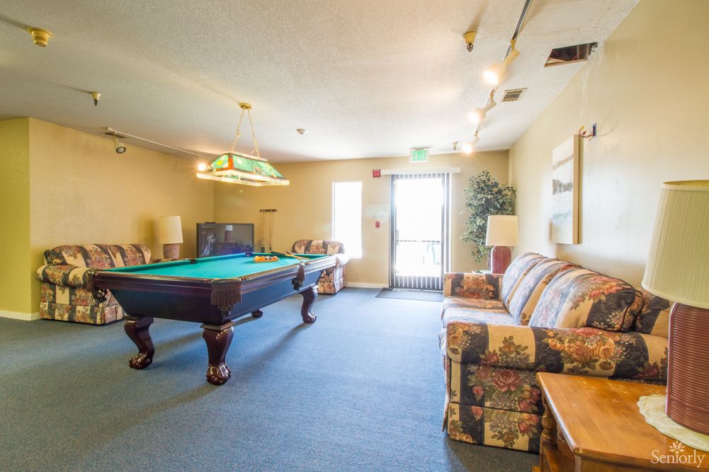 A recreation room featuring a pool table and comfortable seating.