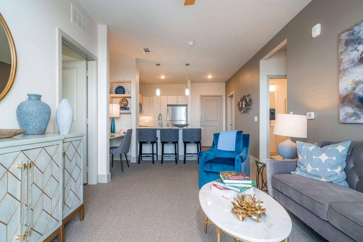 A modern open-concept living space featuring a cozy living room and an adjacent kitchen with bar seating.