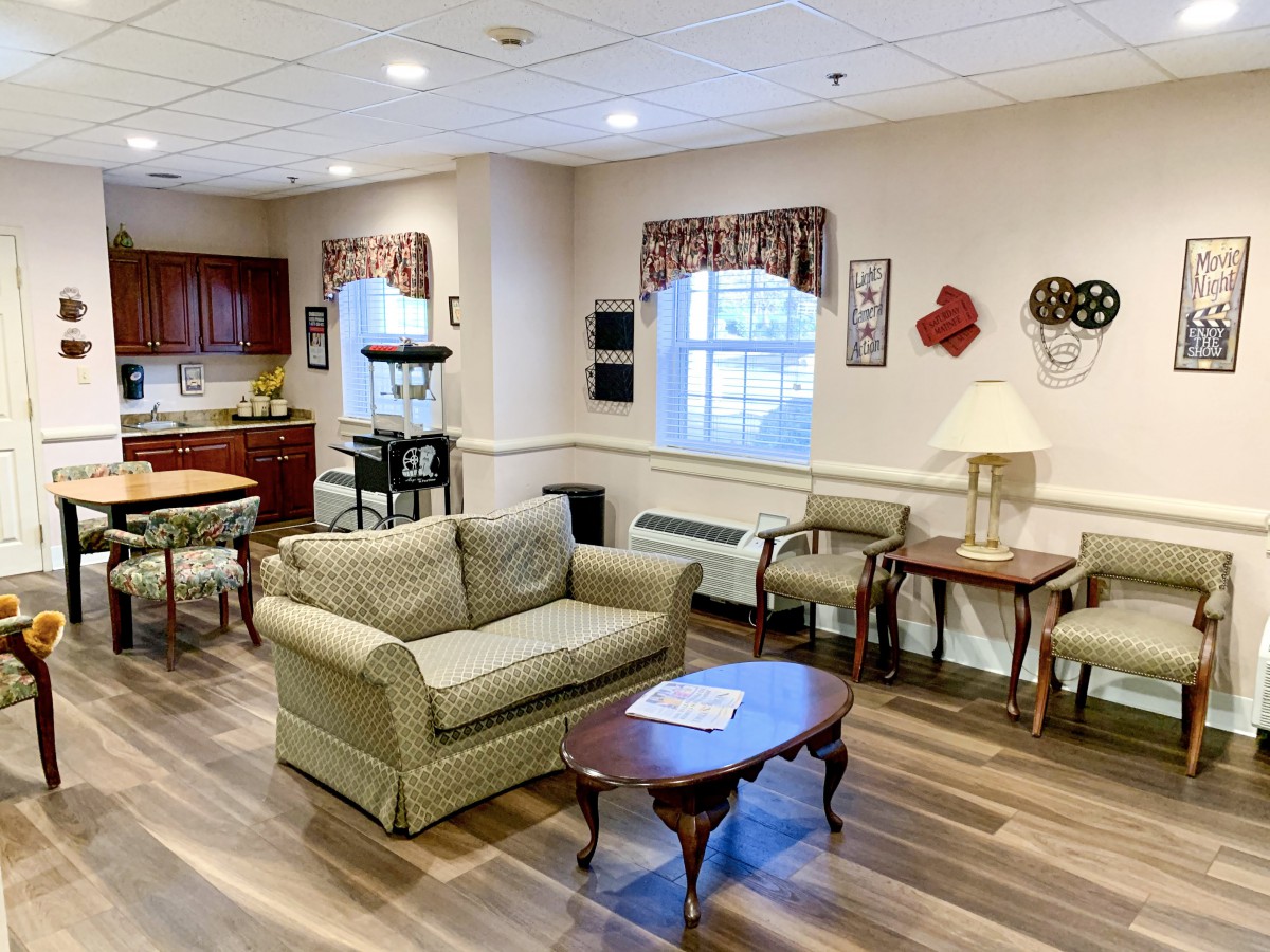 A cozy living room with a sofa, chairs, and wooden flooring.