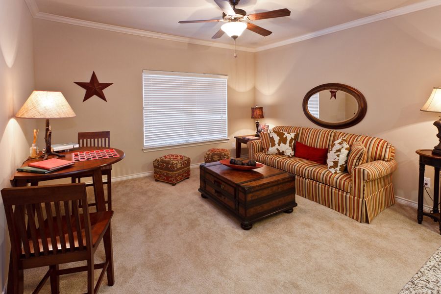 A cozy living room with a striped sofa, wooden coffee table, and warm-toned decor.