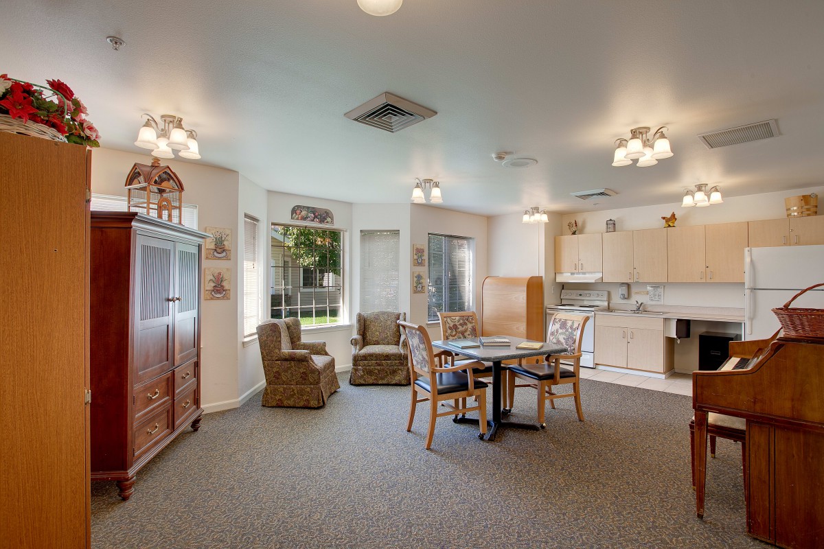 A cozy living space featuring a dining area and kitchenette with ample natural light.