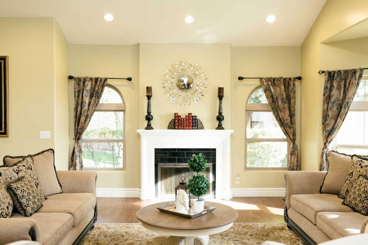 A cozy living room with a central fireplace, elegant decor, and comfortable seating.