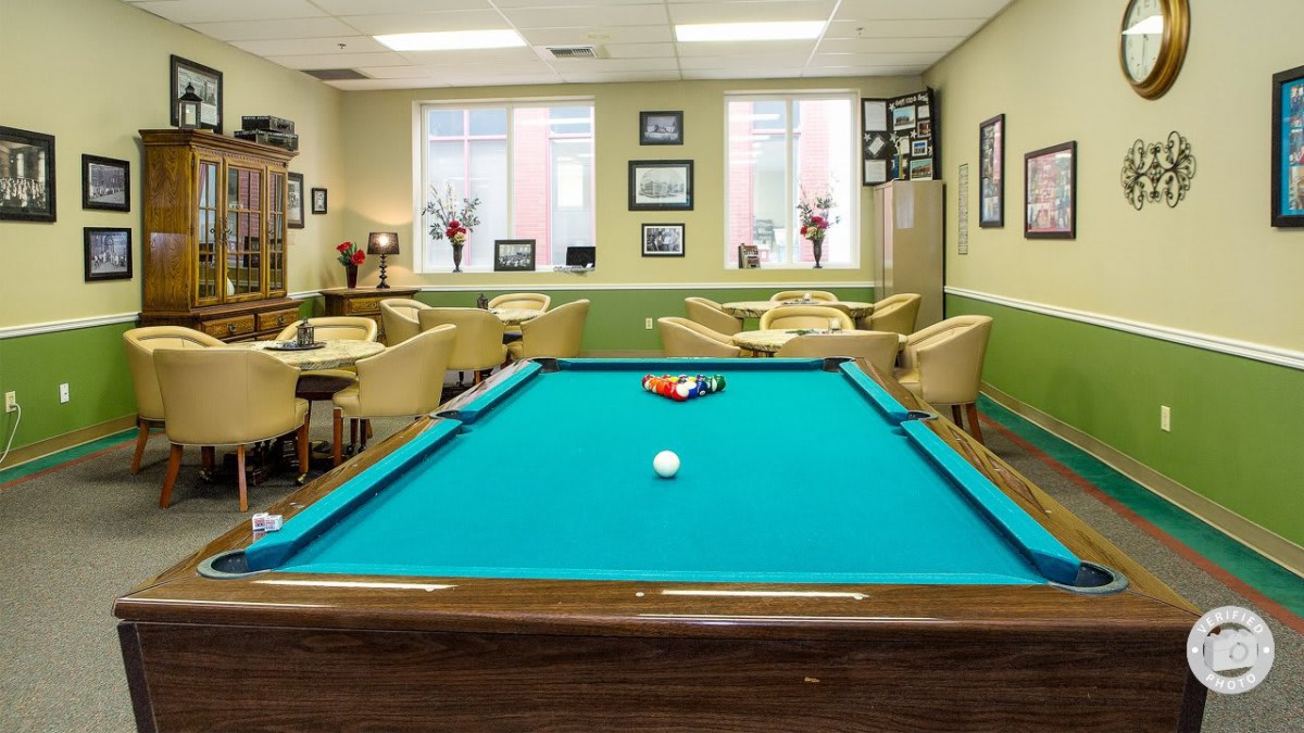 A cozy recreation room featuring a pool table and comfortable seating.