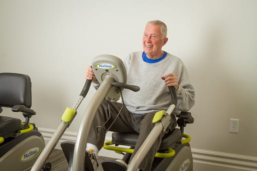 A senior man enjoying a workout session on gym equipment.