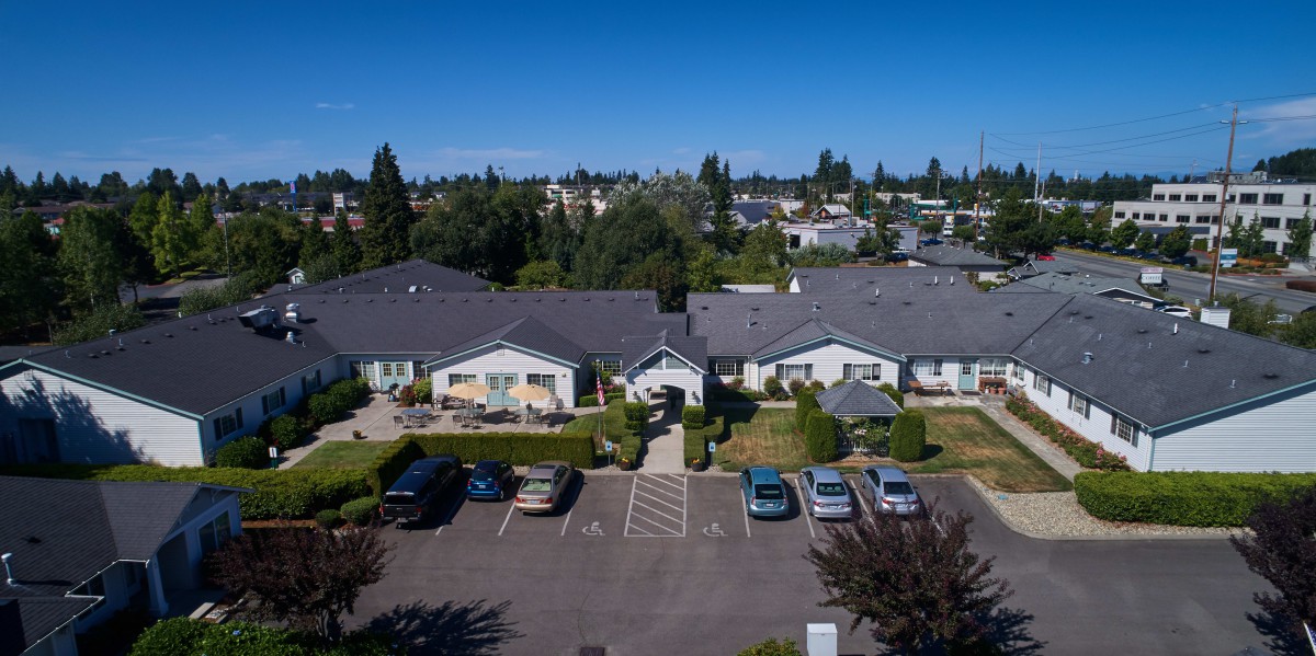 Aerial view of suburban housing with a parking lot in front.