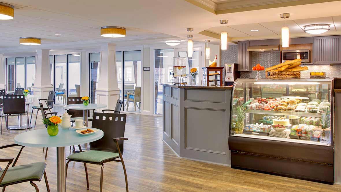 A modern cafe interior with a seating area and display case.