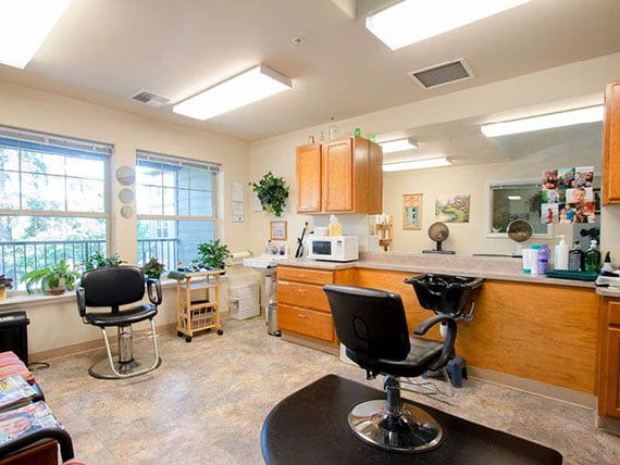 Interior of a hair salon with chairs, mirrors, and cabinetry.