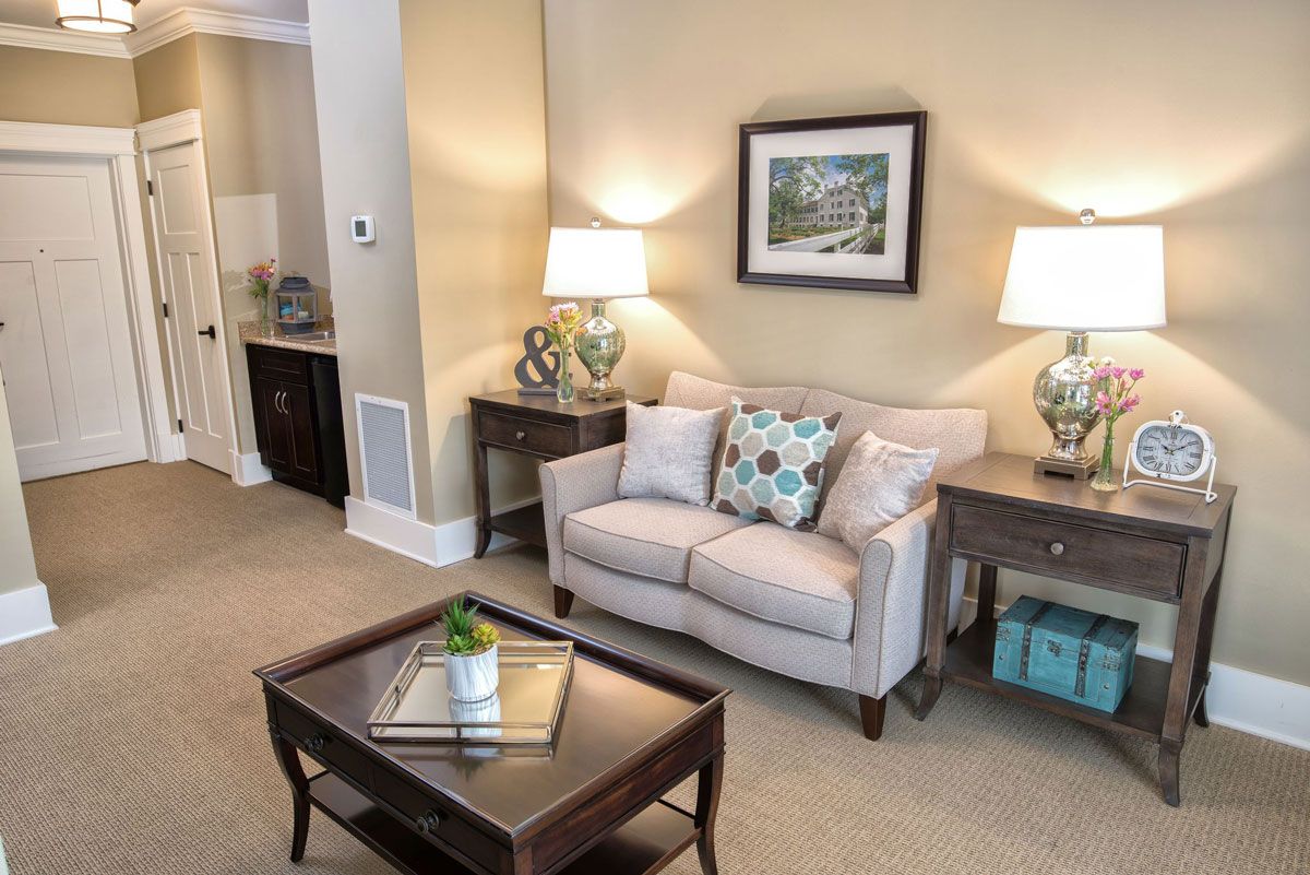 A cozy living room featuring a comfortable sofa, coffee table, and elegant lamps.