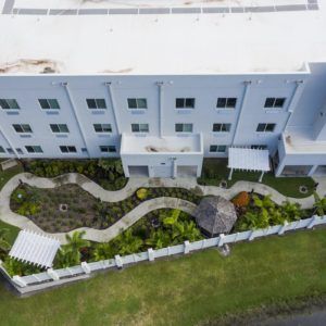 Aerial view of a building with a landscaped garden and winding pathways.