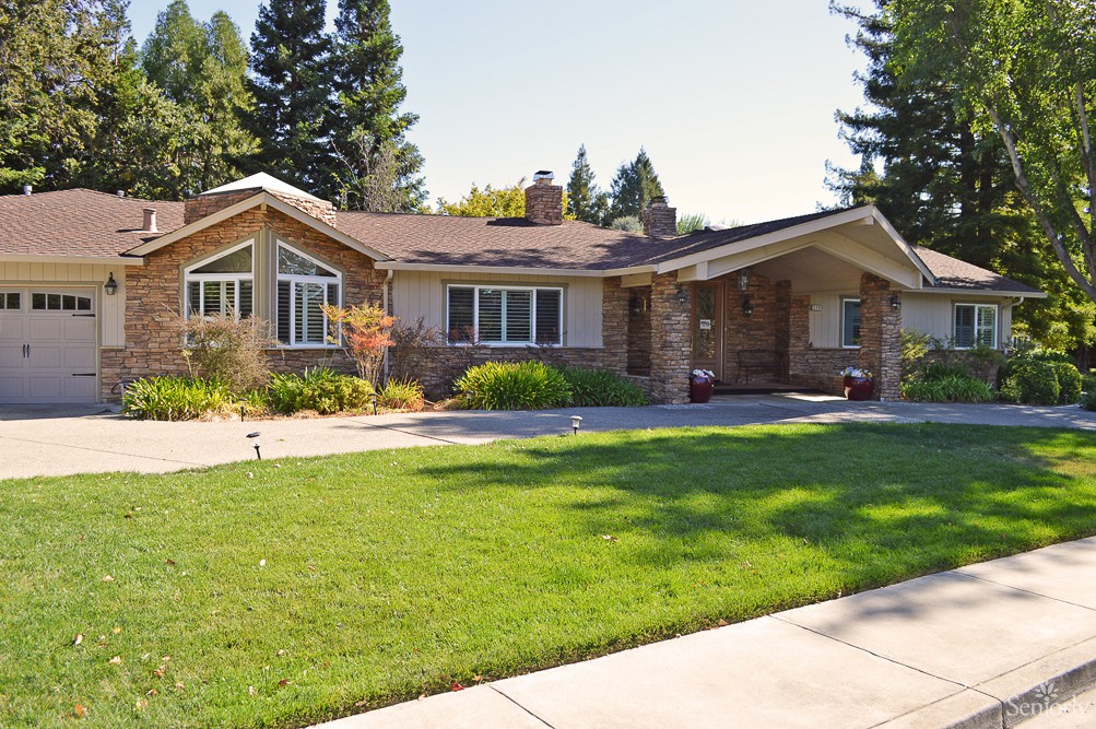A suburban house with a well-maintained lawn and trees.
