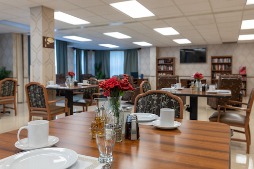 A beautifully arranged dining room featuring elegantly set tables with floral centerpieces.