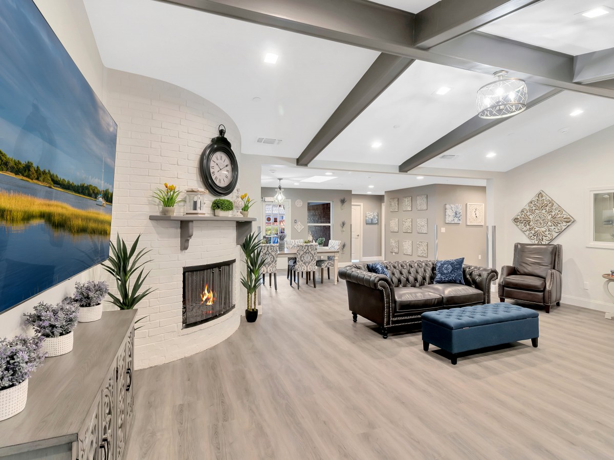 A spacious and modern living room with a fireplace and stylish furniture.