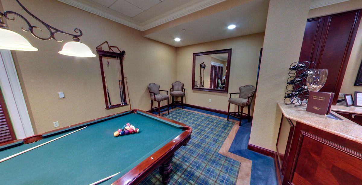 A cozy game room featuring a pool table and seating area.