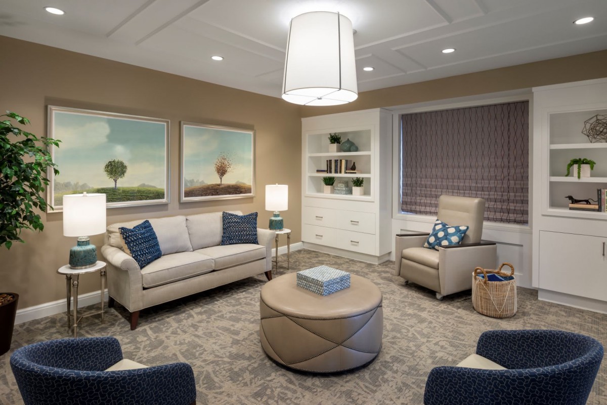 A cozy and modern living room featuring comfortable seating, artwork, and ambient lighting.