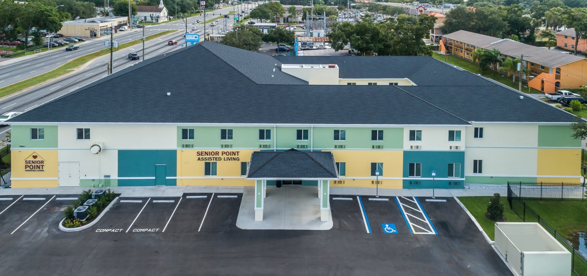 Aerial view of a hotel with a parking lot in front.