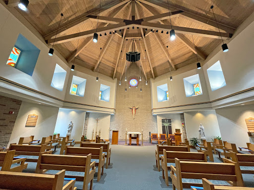 Interior view of a modern church showcasing its beautiful wooden ceiling and serene atmosphere.