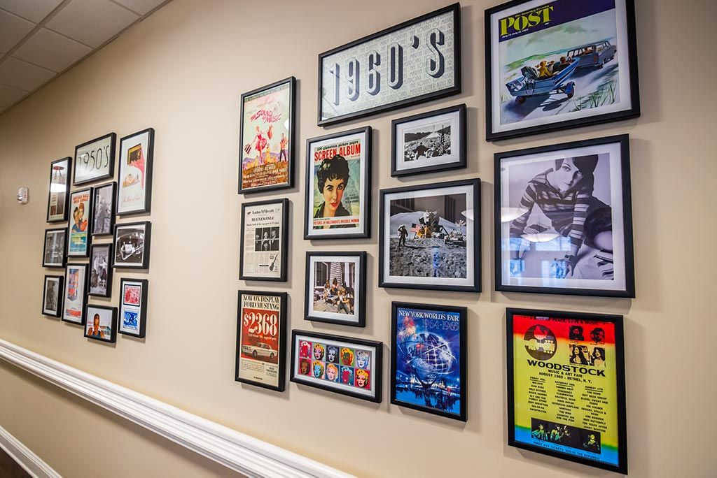 A collection of vintage 1950s-themed posters and memorabilia displayed in black frames on a wall.