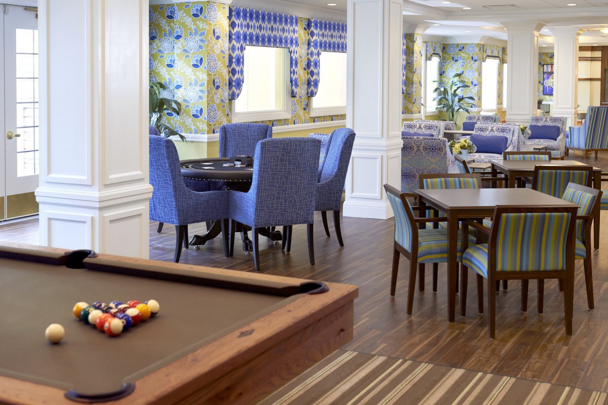 A cozy lounge with a billiards table and dining area, featuring vibrant decor.