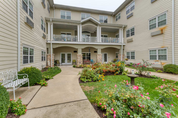 A residential building with a landscaped garden in the foreground.