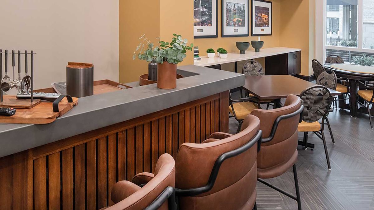 A modern bar interior with comfortable leather seating and decorative plants.