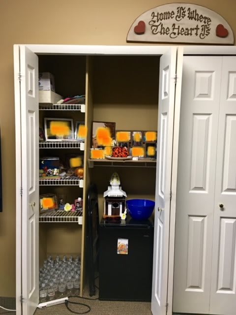 A closet with open doors revealing shelves filled with various boxes and home decor items.