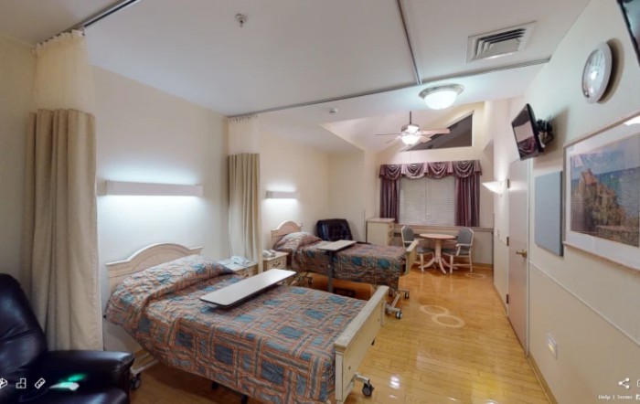 A hospital room with two patient beds and medical equipment.