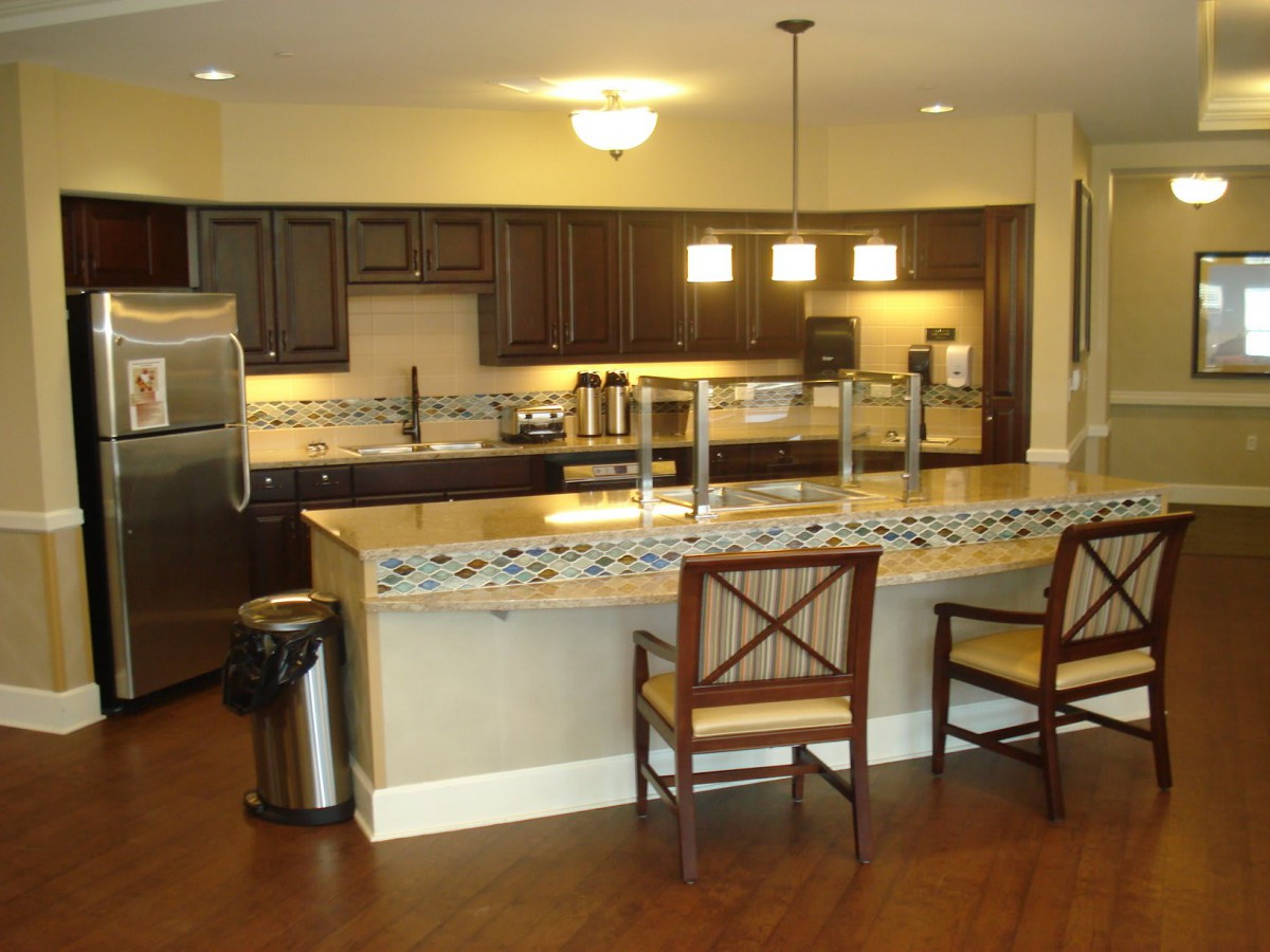 A modern kitchen with wooden cabinets and a central island featuring bar stools.