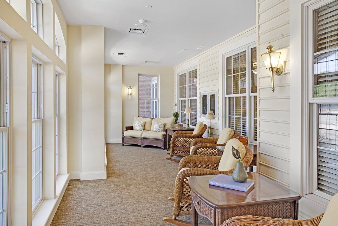 A bright and cozy indoor seating area with wicker furniture and decorative pillows.