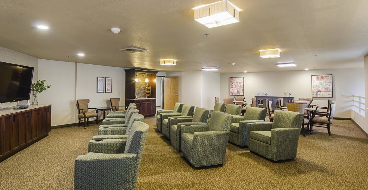 A spacious waiting room with rows of comfortable chairs and warm lighting.