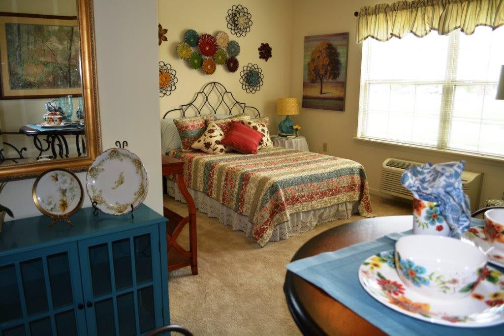 A cozy bedroom with colorful decor and a neatly arranged bed.