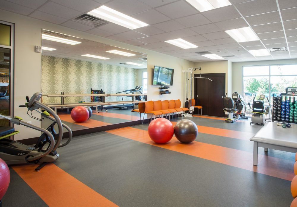 A modern gym studio with exercise equipment and yoga balls.