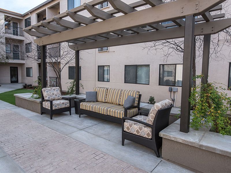 A cozy outdoor seating area with a pergola and stylish patio furniture.