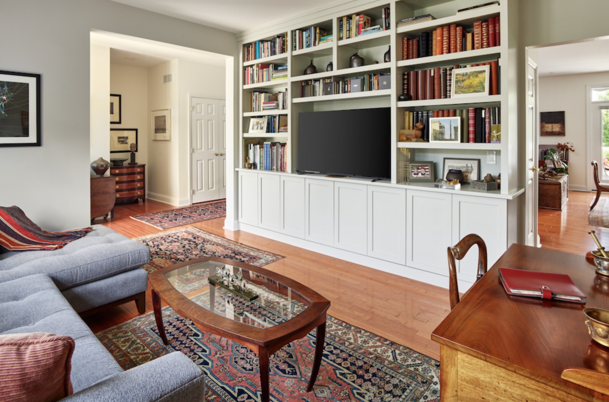 A cozy living room with a built-in bookshelf, television, and elegant wooden furniture.