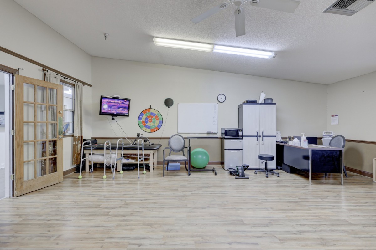 A classroom setting with a whiteboard, chairs, and a television mounted on the wall.