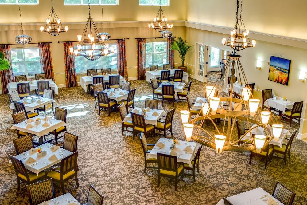 An elegantly decorated dining area with chandeliers and neatly arranged tables.