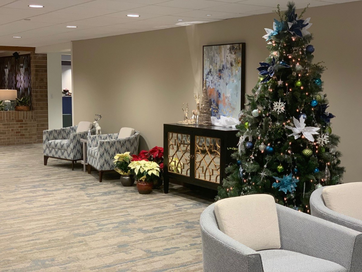 A festive lobby area decorated for the holidays, featuring a Christmas tree and comfortable seating.
